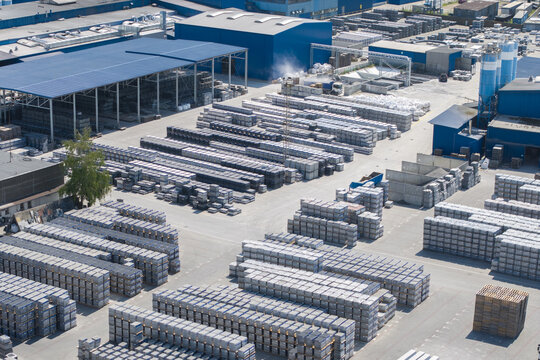 Tarnow, Poland - 31 July 2026: Aerial view of the Bruk-Bet production facility featuring rows of stacked construction materials, industrial buildings with blue roofs, and paved storage yards.