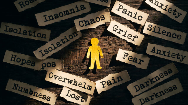 Emotional distress and mental health struggle symbolized by paper person surrounded by negative words