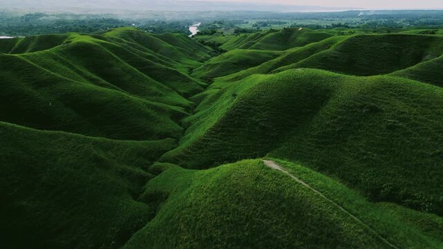 Panoramic view of vast rolling savanna hills at Bukit Tanau in East Sumba, Indonesia