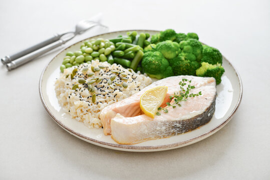 Balanced healthy meal with baked salmon with brown rice and vegetables