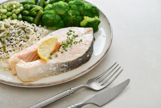 Balanced healthy meal with baked salmon with brown rice and vegetables