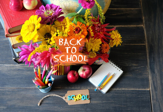 back to school concept. learning books, school stationery, apples, flowers on wooden table. Education, beginning of the school year,  Knowledge Day, 1 September. top view