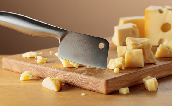 Parmesan cheese and knife on a cutting board.