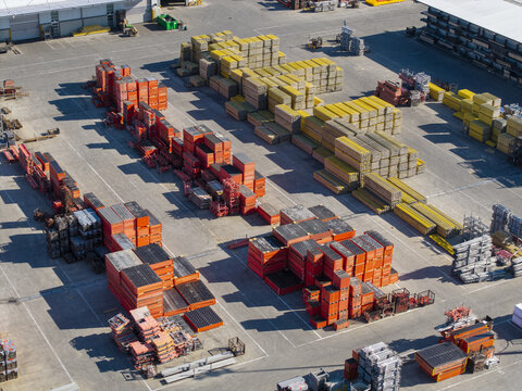 Jaworzno, Poland - 09 August 2026: Aerial view of the PERI Polska facility, featuring organized stacks of orange and yellow construction scaffolding and formwork in an industrial yard.