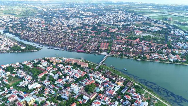 Aerial view of Hoi An Ancient Town, a World Heritage Site by Thu Bon and Hoai Rivers, with a view stretching to the South China Sea. Daylight drone.