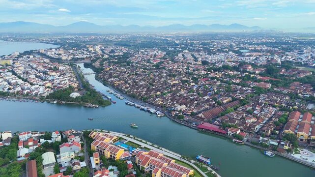 Aerial view of Hoi An Ancient Town, a World Heritage Site by Thu Bon and Hoai Rivers, with a view stretching to the South China Sea. Daylight drone.