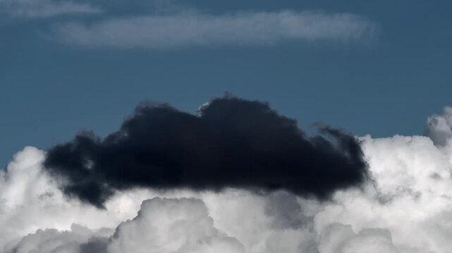 Dynamic clouds featuring bright white cumulus bases overlaid with darker cloud fragments ranging from slate gray to near-black.