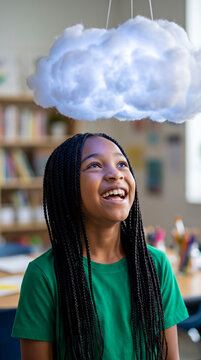 Young girl smiling while looking up at cloud-shaped lamp. Education, child development, creativity, home learning.