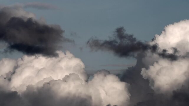 Dynamic clouds featuring bright white cumulus bases overlaid with darker cloud fragments ranging from slate gray to near-black.