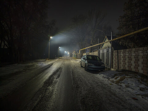 Dark Foggy Night on Residential Street with Minivan
