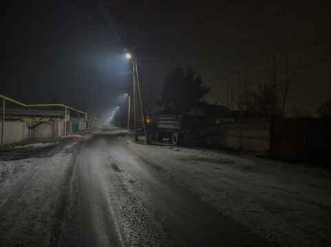 Deserted Rural Road at Night with Street Lamps and Truck