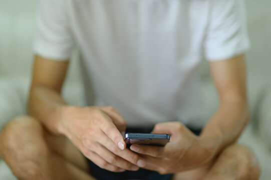 Person Sitting Cross-Legged Using Smartphone in Casual Indoor Setting
