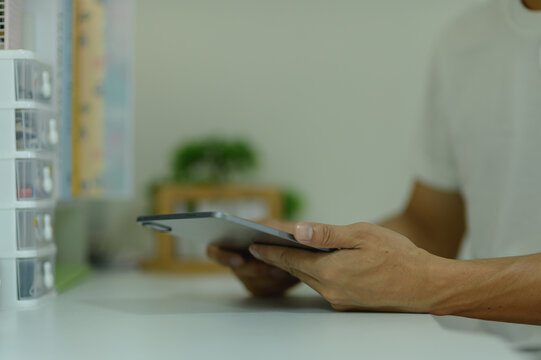 Close-up of person holding tablet device in a modern therapy or medical setting