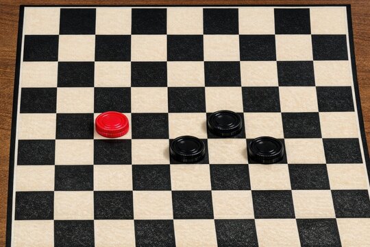 A simple black and white checkered board featuring a bright red button, great for various uses such as puzzles or games