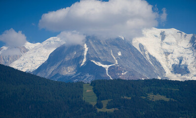 Obraz premium Summer view of the Mont Blanc massif above forested slopes 