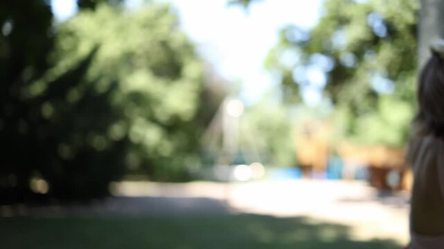 Smiling woman reaches for a pole to steady herself while roller skating in a summer park turning a shaky moment into playful balance practice during an outdoor workout as