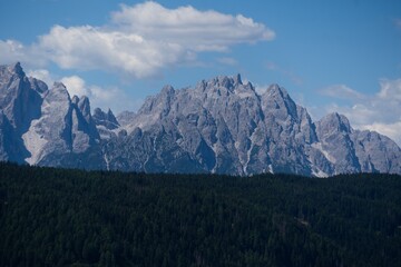 Obraz premium Majestic scenery of rough mountain ridge near grassy hills 
