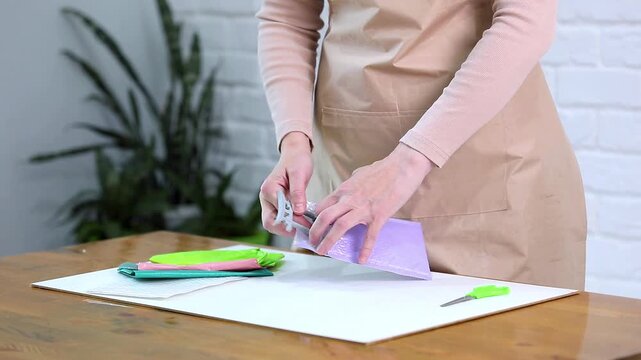 Woman packing Japanese souvenir in bubble wrap padded mailer envelope for shipping