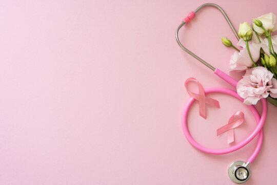 Breast cancer awareness month concept with pink ribbon stethoscope and flower bouquet on pastel background