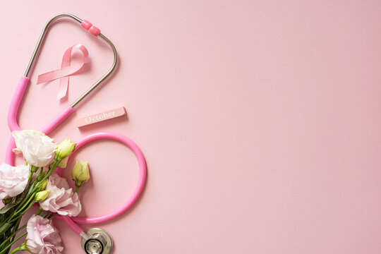 Breast cancer awareness month concept with pink ribbon stethoscope and lisianthus flowers on soft pink background