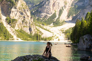Obraz premium Hiking, excited and woman on mountain with lake for adventure, trekking and freedom. Travel, nature and happy person outdoors for wellness, walking and exercise on holiday, journey and vacation
