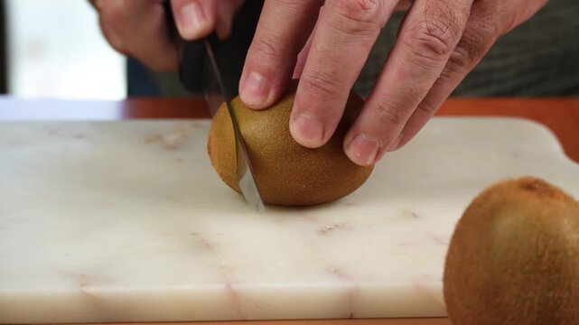 Slicing a Ripe Golden Kiwi with a Kitchen Knife