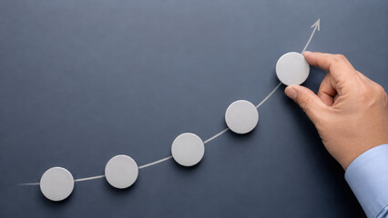 Obraz premium Growth indicators layout concept with hand arranging round objects on upward curve showing positive trend