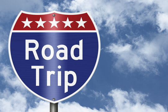Road Trip text on an American interstate road sign on sky for a vacation