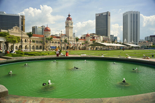 Kuala Lumpur, Malaysıa - November 29, 2015. View of Merdeka Square and Sultan Abdul Samad Building in Kuala Lumpur. View from across a fountain pool, with people and modern buildings.