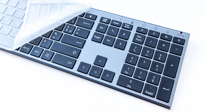 Modern Computer Keyboard with Transparent Silicone Cover on White Table