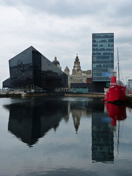 Liverpool, Great Britain &ndash; June 26, 2014. Modern architecture and historic lightship at Canning Dock in Liverpool, England. View with vessels and reflections in water.
