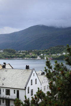 Alesund city roofs, ocean bay and surrounding mountains, Norway. Scandinavian cityscape with traditional coastal houses.
