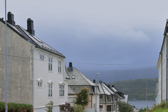 Alesund city roofs, ocean bay and surrounding mountains, Norway. Scandinavian cityscape with traditional coastal houses.