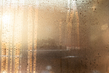 Condensation glass window droplet moisture texture abstract condensation covered glass window with water droplet texture and warm light creating private, atmospheric surface for background design