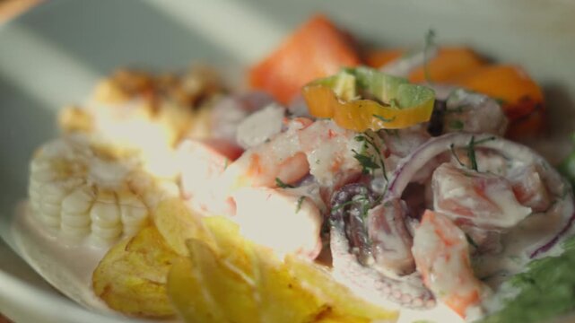Delicious plate of fresh peruvian seafood ceviche served with sweet potato, corn, and fried plantain