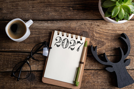 New year resolutions 2027 on desk. 2027 resolutions list with notebook, coffee cup on table. Goals, resolutions, plan, action, checklist concept. New Year 2027 template, copy space