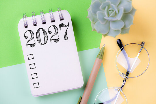 New year resolutions 2027 on desk. 2027 goals list with notebook, coffee cup, plant. Resolutions, plan, goals, action, checklist, idea concept. New Year 2027 resolutions, copy space