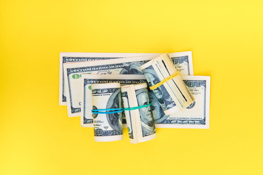 Stack and rolls of hundred dollar bills