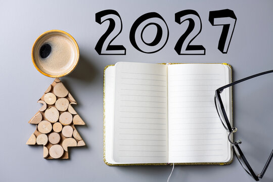 2027 New year resolutions on desk. 2027 goals list with notebook, coffee cup, plant on table. Resolutions, plan, goals, action, checklist, idea concept. New Year 2027 resolutions. Copy space