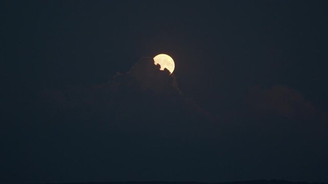 Full Moon appears from the clouds during moonrise