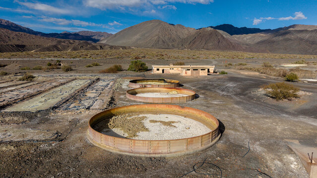 Calingasta, San Juan, Argentina - 16 July 2026: Aerial view of the Ruinas de Planta de Sulfato de Aluminio with circular industrial tanks and abandoned structures in a rugged mountain landscape.