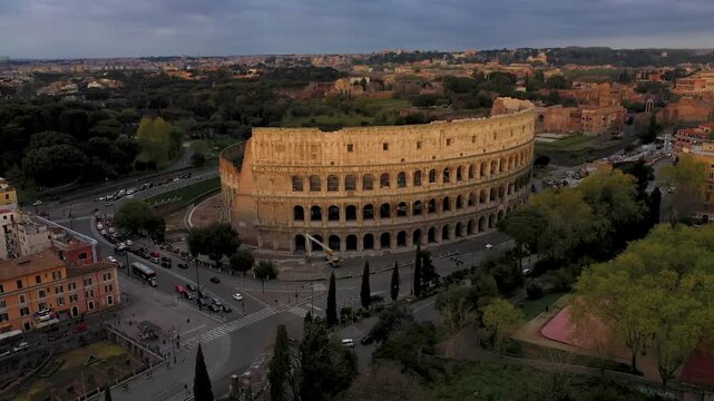 Aerial 4K video footage of Roman Colosseum at sunrise. Ancient amphitheater bathed in golden light.