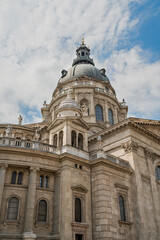 Obraz premium Upward view of the copper dome and statue lined balustrade of Saint Stephen's Basilica in Budapest, Hungary