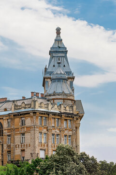Ornate rooftop towers and weathered facade of Anker Palace in the Terezvaros district of Budapest, Hungary