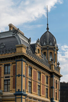 Historic side pavilion with patterned brickwork and domed tower at Nyugati Railway Station in Budapest, Hungary