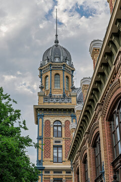 Historic domed corner pavilion of Nyugati Railway Station rising behind brick arches in Budapest, Hungary