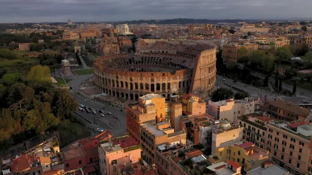 Aerial 4K video footage of Roman Colosseum at sunrise. Ancient amphitheater bathed in golden light.