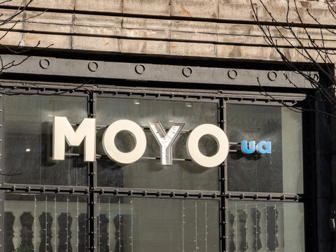 Kyiv, Ukraine - March 15, 2026: Moyo signage mounted on a dark iron store front window, featuring illuminated white lettering representing retail technology and consumer electronics