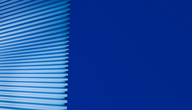 Blue metal roller shutter door with horizontal ridges and solid wall