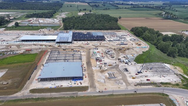 Saline, United States - 07 August 2026: Aerial view of construction site with steel frameworks, heavy machinery, and earthworks in a rural landscape.